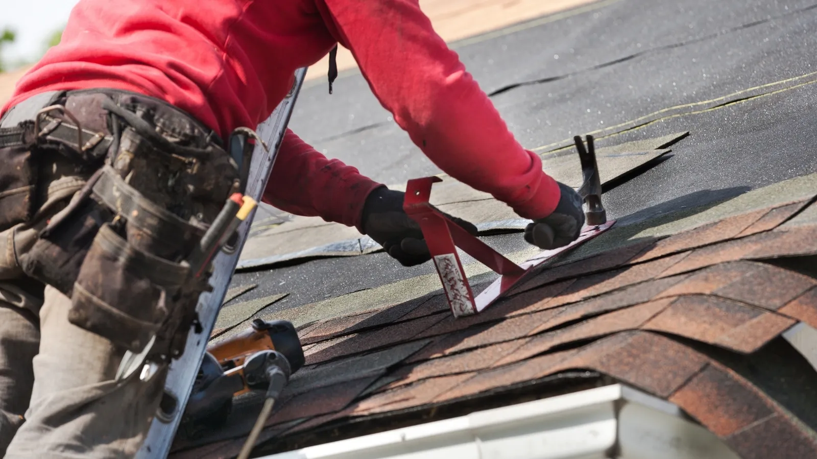 Roof bracket hammered onto new shingles by a roofer